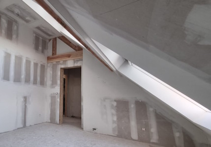 Aménagement d'un grenier à Beersel - Finition du gyproc à la porte de la chambre