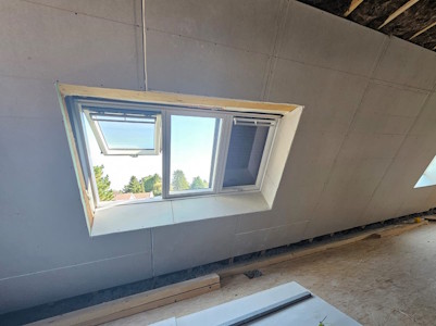 Aménagement d'un grenier à Overijse - Pose des plaques de plâtre autour du Velux 3en1